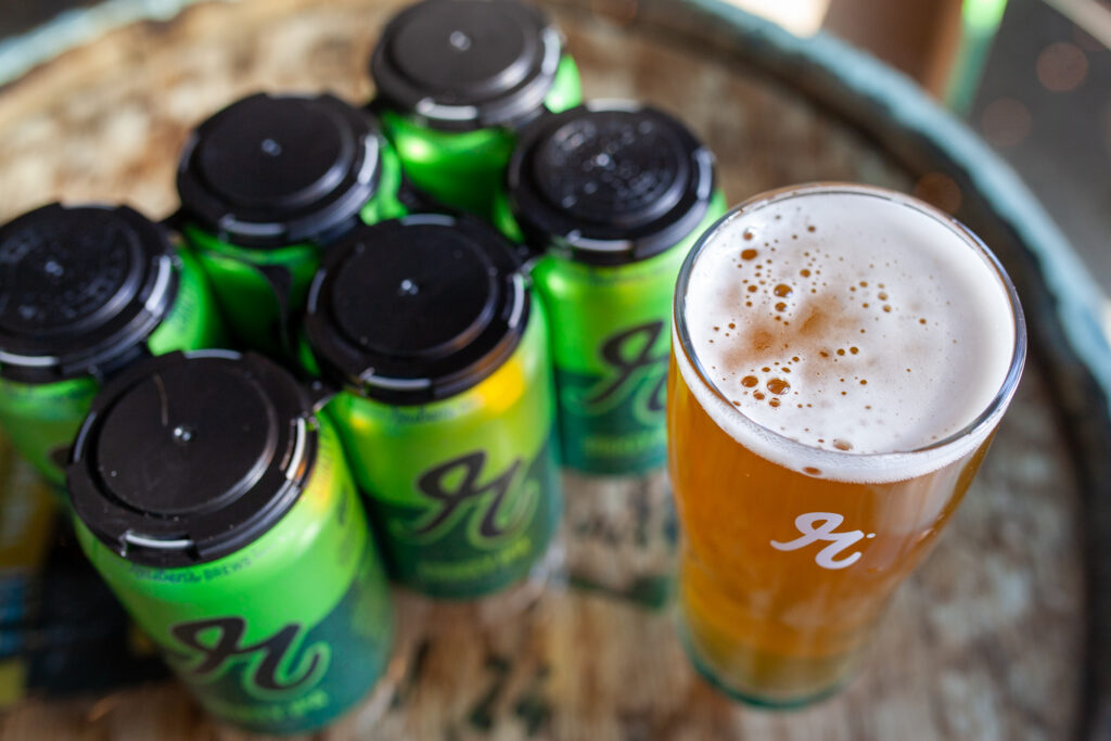 A pint of Crikey IPA with a 6-pack of cans. 